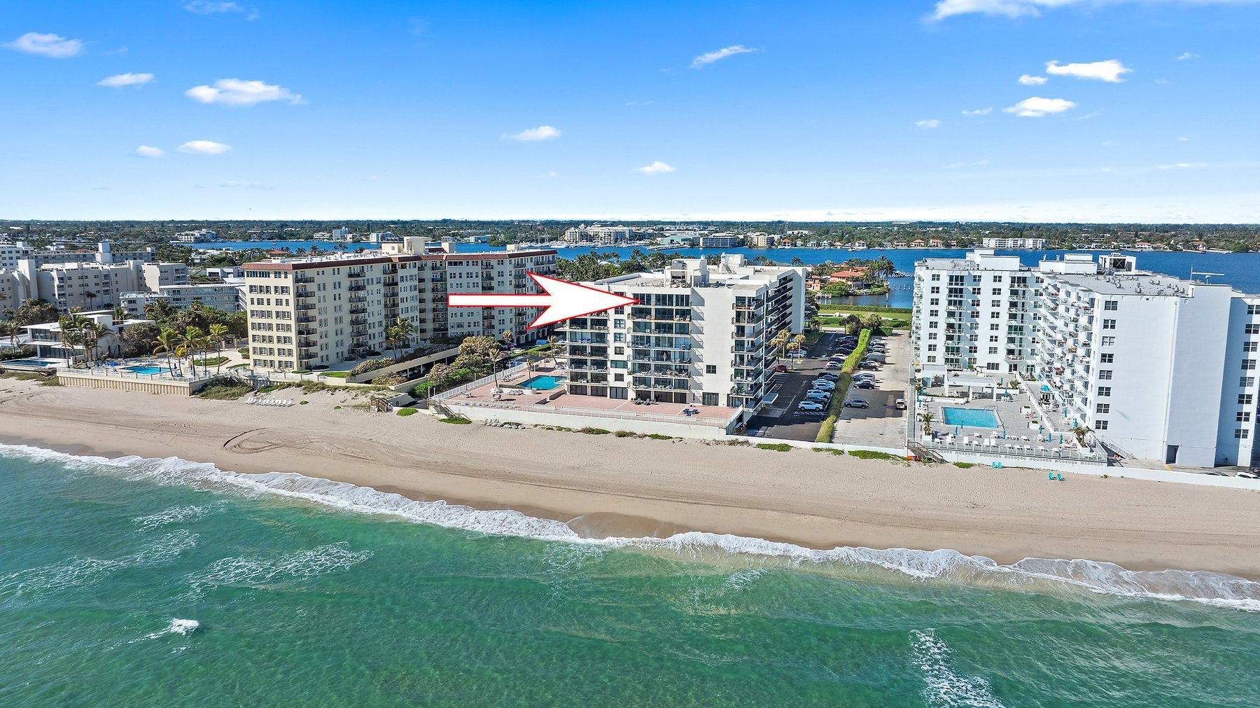 Aerial view of The Claridges at 3456 South Ocean Boulevard, direct oceanfront condominium in Palm Beach Florida, marked with arrow indicating the building location on the sand