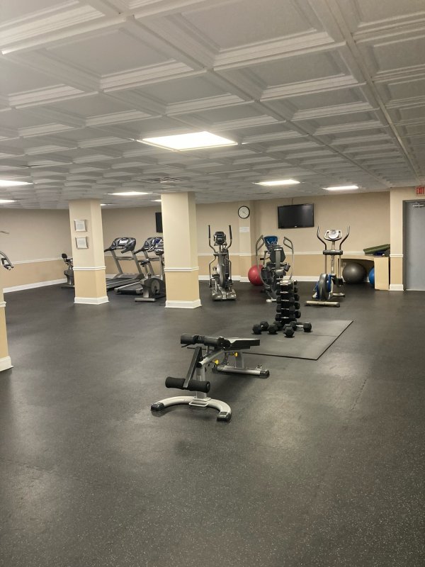 Residents' fitness center at The Claridges Palm Beach with cardio equipment and free weights