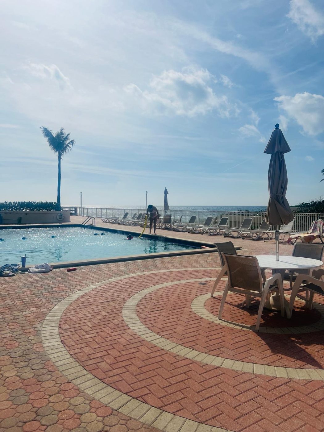 Pool deck wide view at The Claridges with lounge chairs and umbrellas